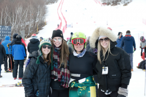 Three friends of post author Libby McCusker join her for a photo and to cheer her on during a ski race in Lake Placid.