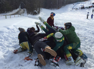 Members of Clarkson's alpine ski team form a celebratory pile on the snow after finding out that they advanced to the national championship!
