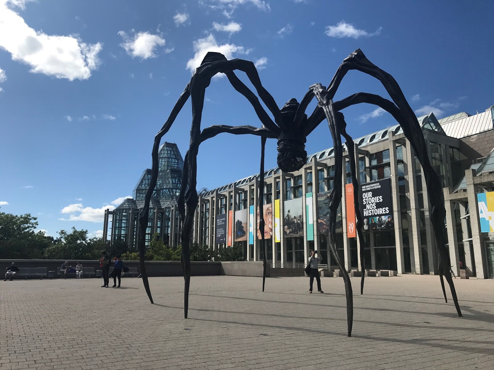 A large sculpture of a spider stands in front of a museum in Canada.
