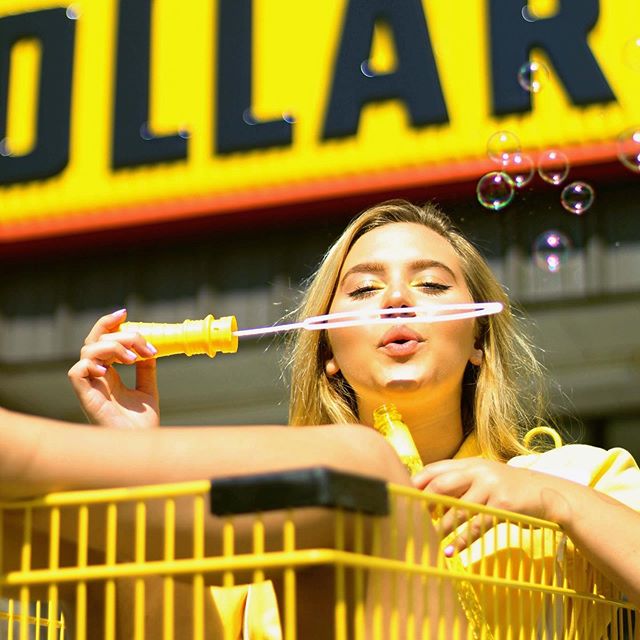 A model has her photo taken blowing bubbles in front of Dollar Tree by Clarkson student Jada Flanagan in downtown Potsdam, New York. 