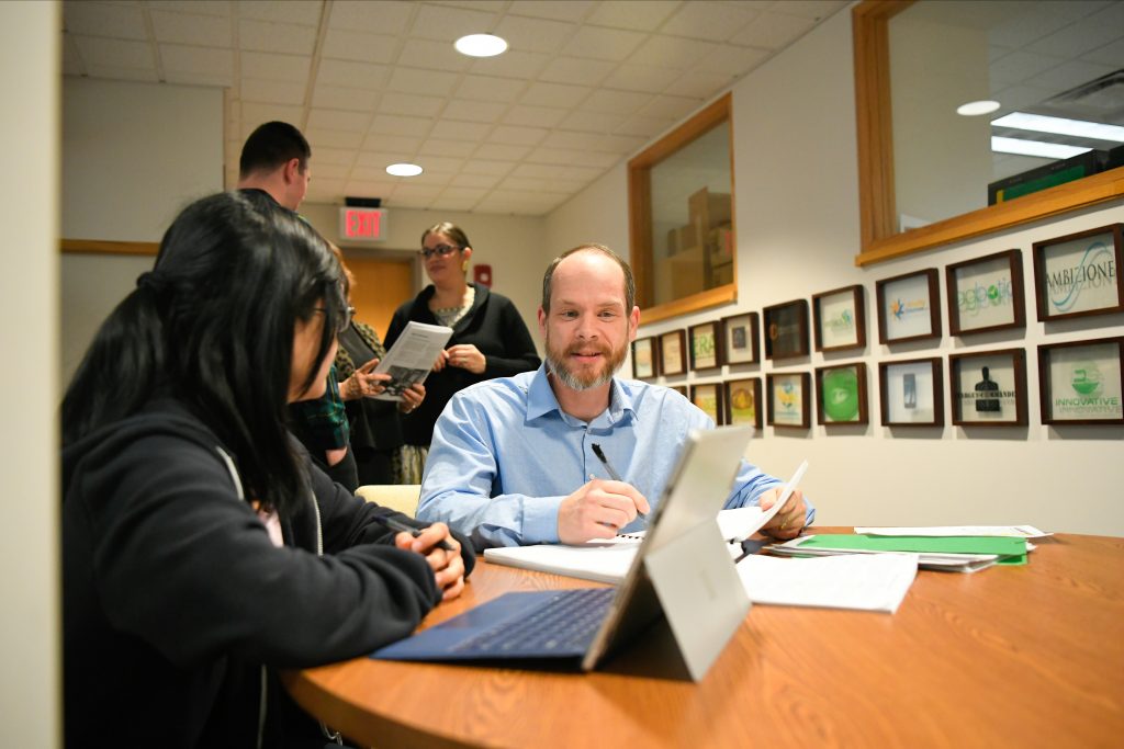 An academic advisor sits with a student