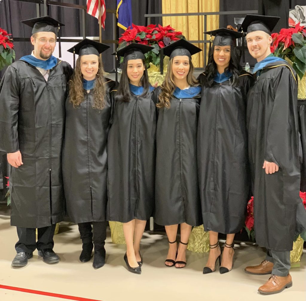 Clarkson occupational therapy alumnus Dustin Brown poses at his master's in OT graduation ceremony with five fellow graduates. 