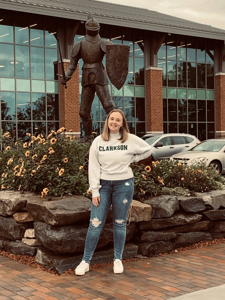 Cassidy Marshall, class of 2025, poses in front of the Clarkson University Golden Knight statue.