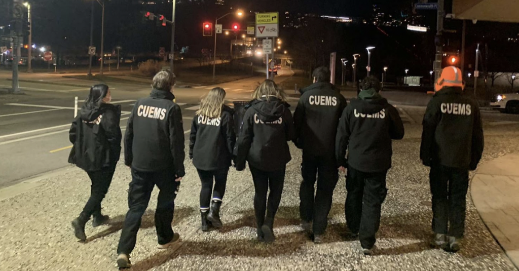 Clarkson CUEMS students walk down a street wearing their CUEMS coats